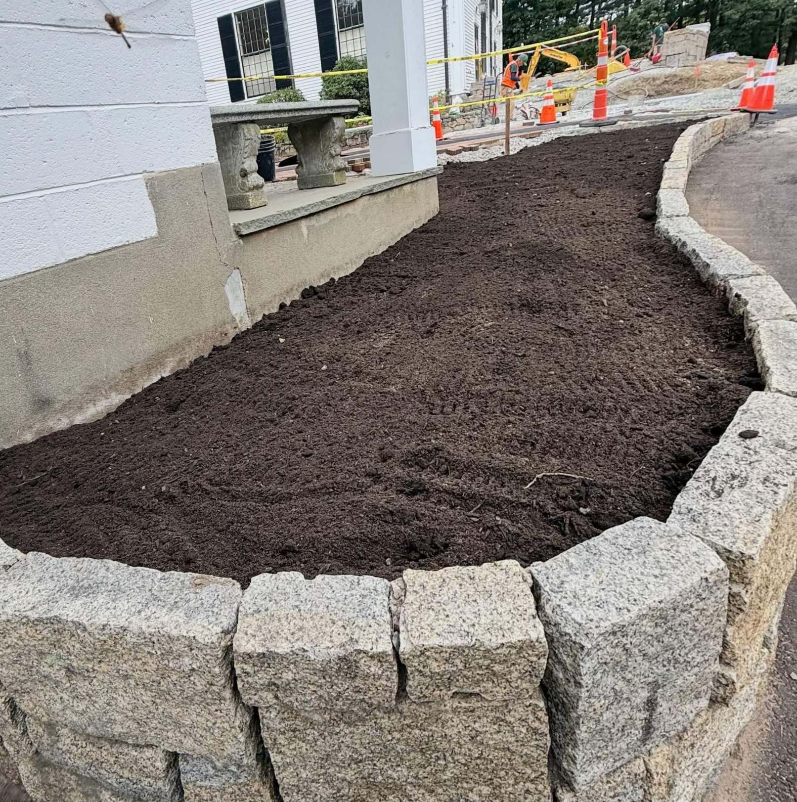 After: the same bed filled with fresh dark loam, ready to plant