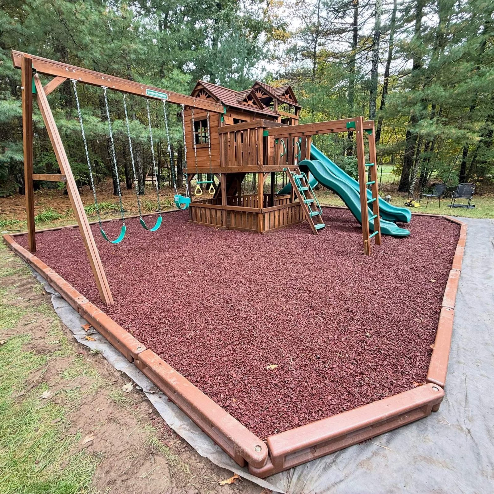 Wooden playset on red playground mulch